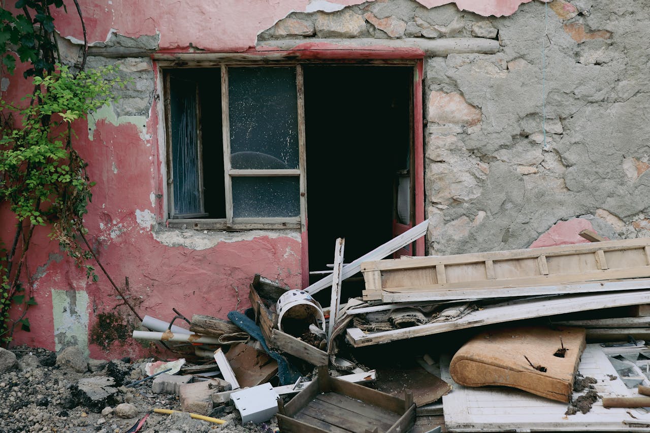 Pile of renovation debris and construction waste outside a damaged building, highlighting the importance of proper renovation debris disposal